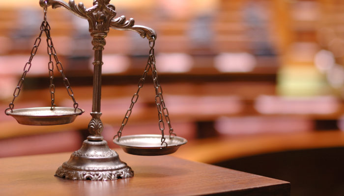 Pursuing Personal Injury Compensation - Decorative Scales of Justice in the Courtroom